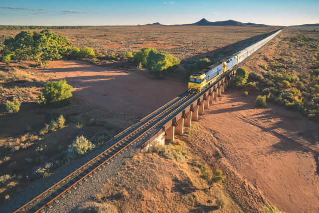 The-Indian-Pacific-heading-east-towards-Broken-Hill-with-the-Pinnacles-Mountains-in-background-1.-low_res-scale-6_00x-gigapixel